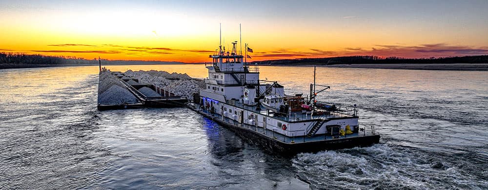 Barge on the river moving rock