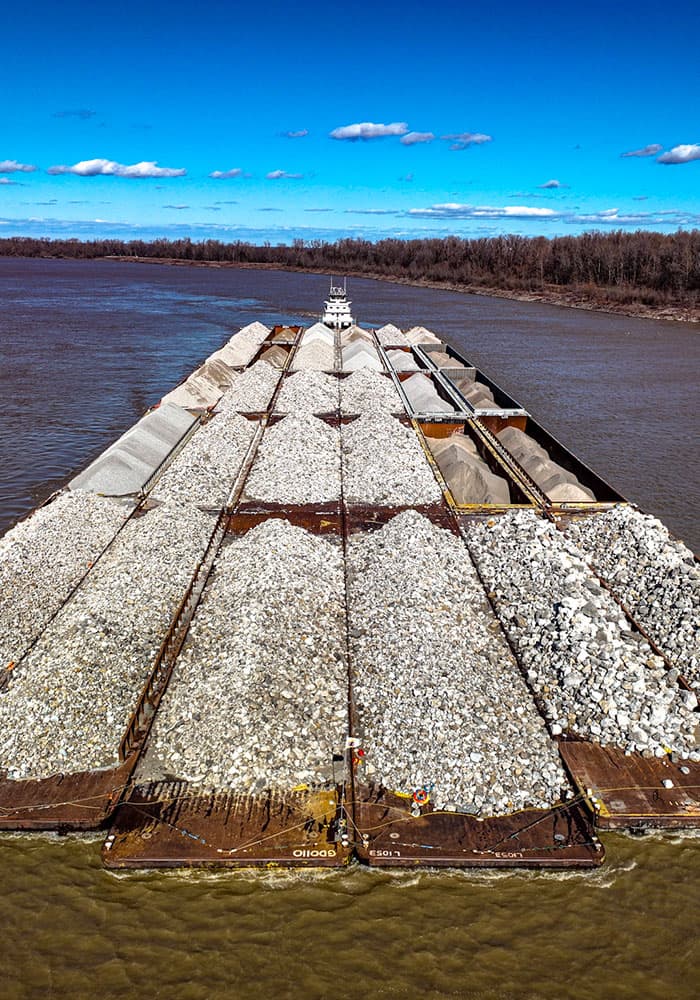 tugboat pushing barge with rock